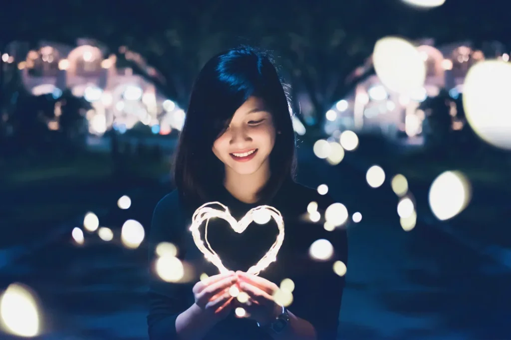 Image of girl holding a heart with light all around