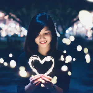 Image of girl holding a heart with light all around