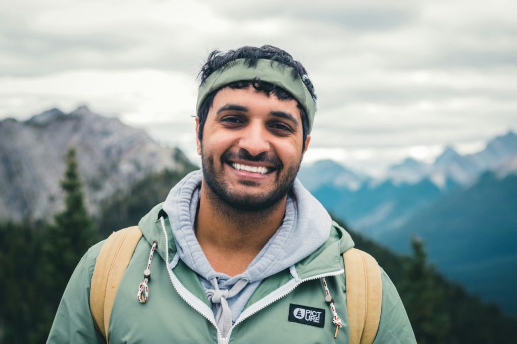 Smiling man on top of a mountain