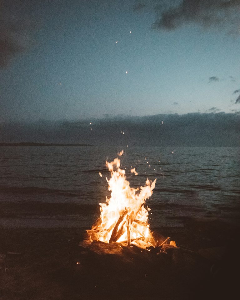Fire set on the beach overlooking watery ocean